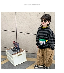 Detail of a color-block kids crossbody bag paired with a striped sweatshirt for casual wear