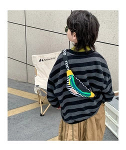 Kids color-block crossbody bag with letter print strap worn by a model in outdoor setting
