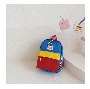 Detail of color-block kids backpack with red blue yellow panels and brand logo