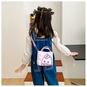 Fille portant un sac à main en toile licorne violette dans un décor minimaliste