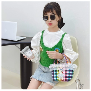 Fille en gilet crocheté avec sac à main lapin et jupe en jean délavé chic