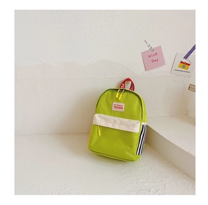 Detail of vibrant green canvas kids backpack with contrast zipper pocket and woven straps