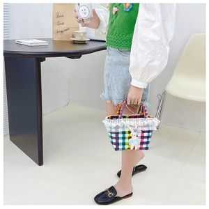 Détail d'un sac de plage tressé à carreaux pour filles avec dentelle et charm de lapin