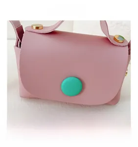 Detail of pink PU leather girls crossbody bag with a large green decorative button