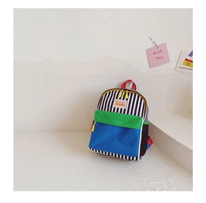 Detail of color-block canvas kids backpack with striped patterns and woven red handle