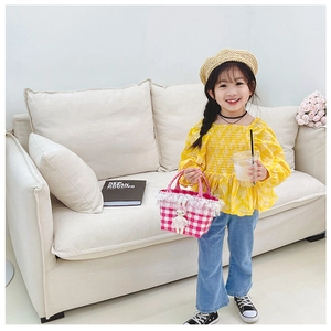 Détail du haut floral jaune et du sac à main en dentelle à carreaux pour filles
