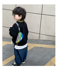 Close-up of kids color-block waist bag with lettered straps and striped details
