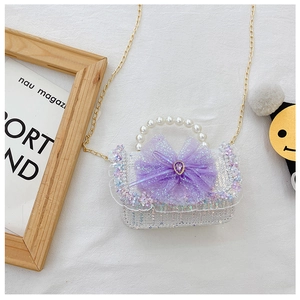 Detail view of girls sequin bag with purple mesh bow, gem accent and pearl handle
