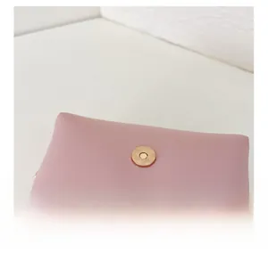 Close-up of pink leather handbag showing secure magnetic snap closure and fine texture