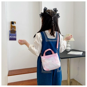 Sac bandoulière en toile dégradé rose avec motif ours porté par une petite fille