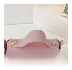 Detail view of pink PU leather girls handbag featuring comfortable handle and gold rivets