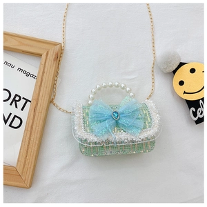 Macro detail of kids crossbody bag featuring sequin tweed, lace edges and blue mesh bow