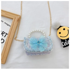 Detail showing light blue tweed texture with sequins and large mesh bow with jewel