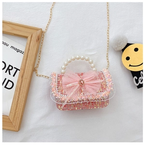 Detail of pink tweed bag with pearl handle, mesh bow and golden chain strap for girls