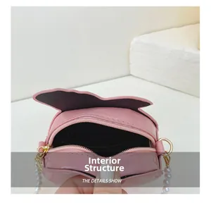 Detail of pink patent leather cat ear bag interior with pearl chain strap
