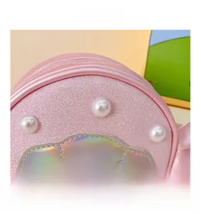 Detail of pink sequin shell bag featuring pearl accents and laser texture finish