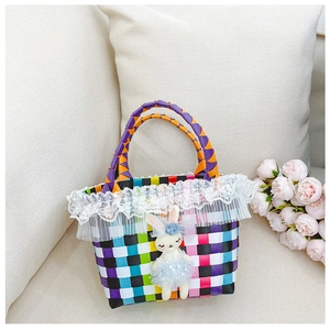 Détail du sac tressé coloré avec bordure en dentelle blanche et pendentif lapin mignon