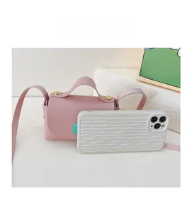 Pink mini crossbody bag for girls shown next to a smartphone to demonstrate tiny size