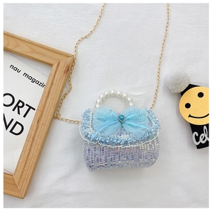 Detail of tweed girls handbag with pearl handle, mesh bow and heart-shaped blue gemstone