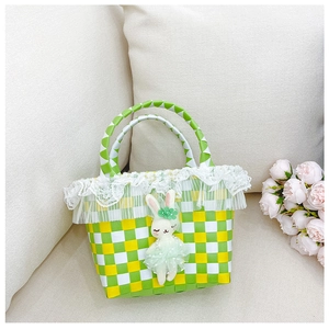 Détail du sac de plage tressé avec motif en damier vert et adorable lapin en peluche