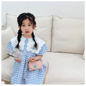 Detail view of pink girls' mini crossbody bag paired with a plaid bubble sleeve dress