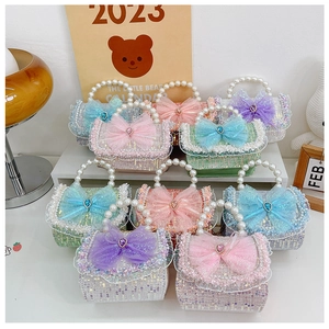 Detailed view of colorful sequin mini purses with pearl handles and lace bow accents