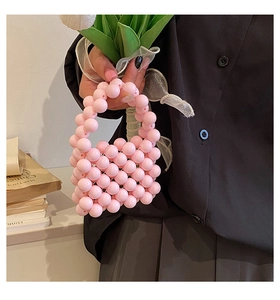 Detail of pink pearly beaded mini handbag with handmade woven texture and top handle