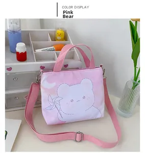 Détail du sac bandoulière en toile rose avec illustration d'ours et bandoulière rose