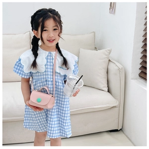 Detailed view of pink mini PU leather crossbody bag for girls with green button accent