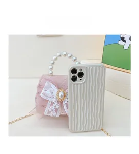 Vue détaillée du mini sac en dentelle rose avec poignée en perles et chaîne dorée