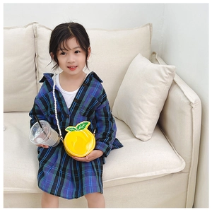 Close-up of cute yellow orange-shaped girl's crossbody bag with elegant pearl strap detail