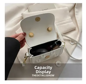 Detailansicht der weißen Mini-Tasche mit Hasenprägung und Innenausstattung aus Goldmetall