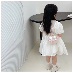 Détail d'un sac à main rose en dentelle pour fille avec nœud et poignée perlée