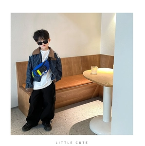 Détail du sac de poitrine tendance bleu et noir sur une tenue stylée en toile garçon