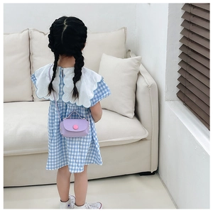 Detail of girl's mini lilac PU crossbody bag with pink round button and single handle
