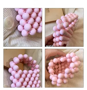 Close-up of pink handmade beaded handbag featuring high-gloss pearls and woven details