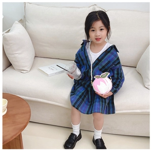 Girl's pink peach crossbody bag with pearl chain strap styled on a plaid shirt
