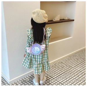Detail of girl wearing sequined purple shell bag with pearl decor and plaid dress