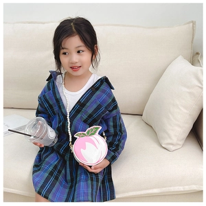 Detailed view of kids peach crossbody bag with white faux pearl chain and green leaf deco