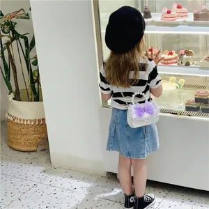 Girls' white sequin mini handbag with purple tulle bow and pearl handle in lifestyle setting