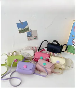 Detailed flat lay of colorful mini PU crossbody bags with cute oversized button accents