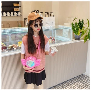 Pink shell shaped crossbody bag with pearl accents and sequin details on a young girl