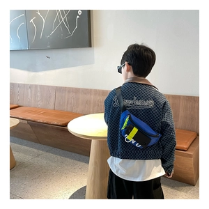 Détail d'un sac de poitrine tendance bleu pour enfant avec sangles jaune fluo porté