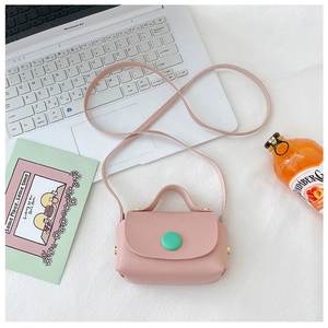 Detailed view of a pink mini PU leather crossbody bag with green button and gold hardware