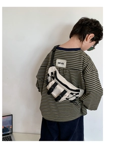 Detail of canvas kids crossbody bag featuring adjustable nylon straps and plastic buckles