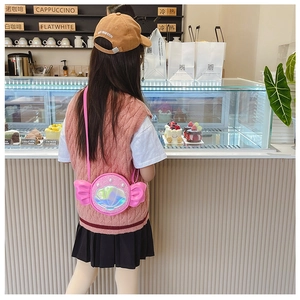 Pink girl's crossbody bag with sequin shell and 3D bow details shown on a child model