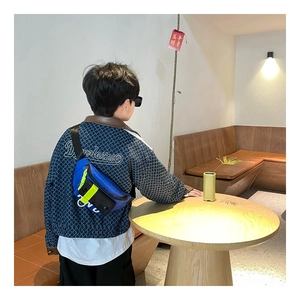 Détail du sac bandoulière enfant en toile avec sangle réglable jaune et bleue contrastée