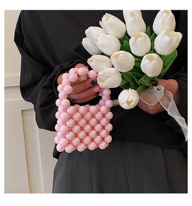 Detail of pink pearl beaded mini handbag with top handle held by a person
