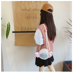 Girl's white round crossbody bag with sequined shell details shown on model's shoulder