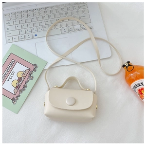 Minimalist cream white mini PU leather crossbody bag for girls on a lifestyle desk background